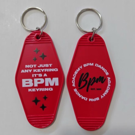 Two red BPM motel keyrings: one reads Not just any keyring, it’s a BPM keyring; the other has the round BPM logo